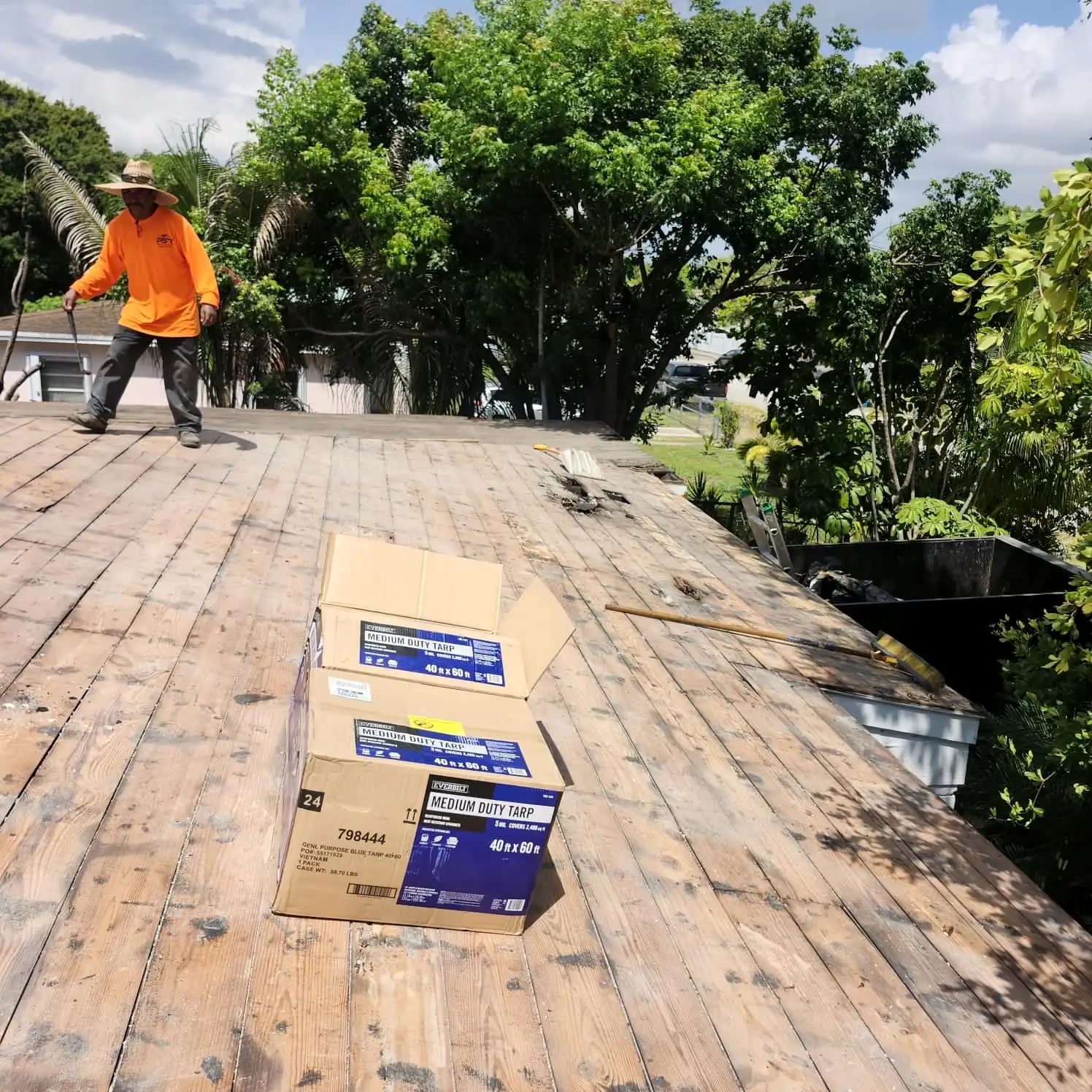 PSR crew member on a roof deck with boxes of roofing materials