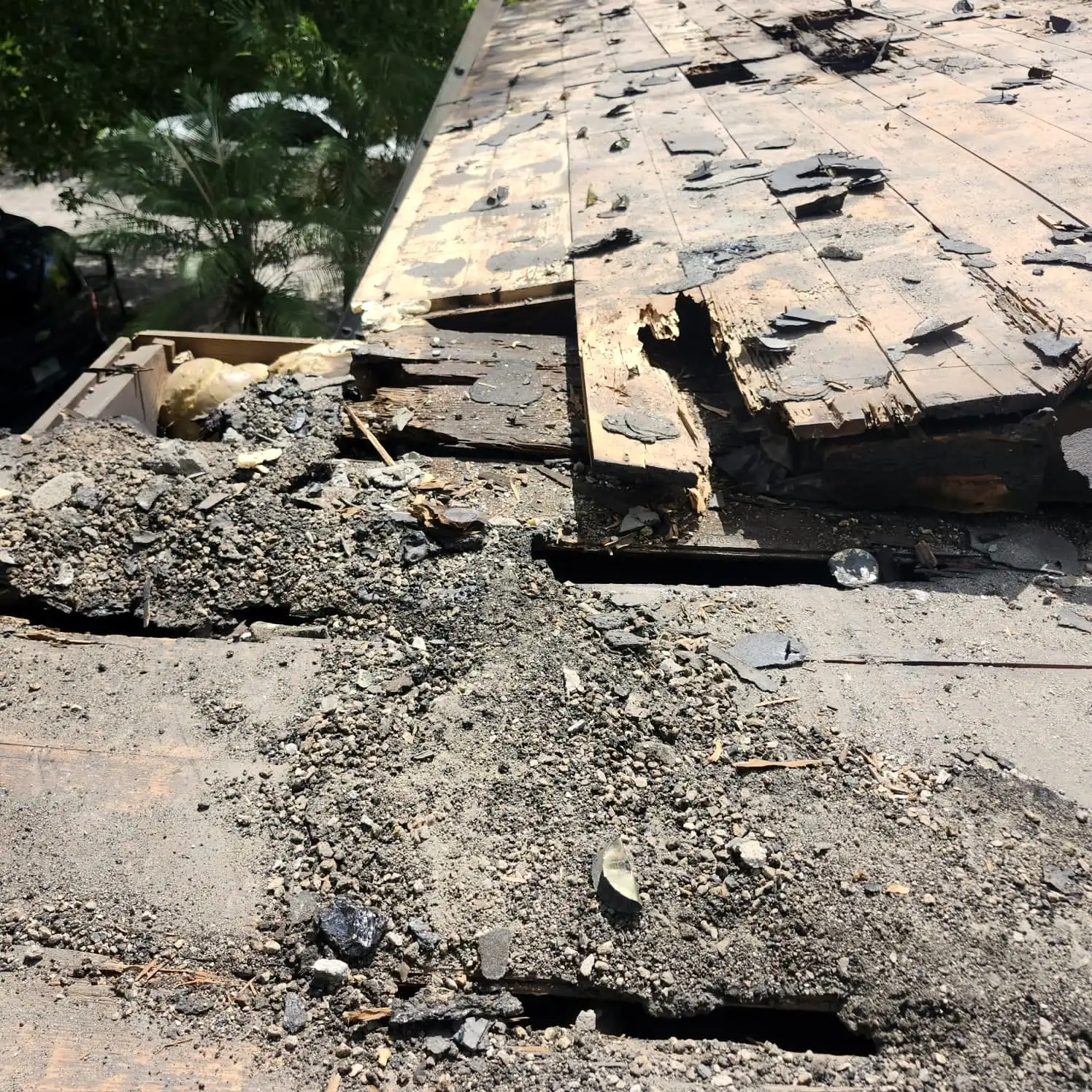 Storm-damaged roofing torn back to the deck
