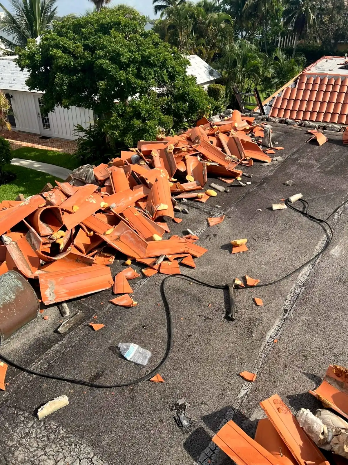 Old clay tile being removed during a roof replacement